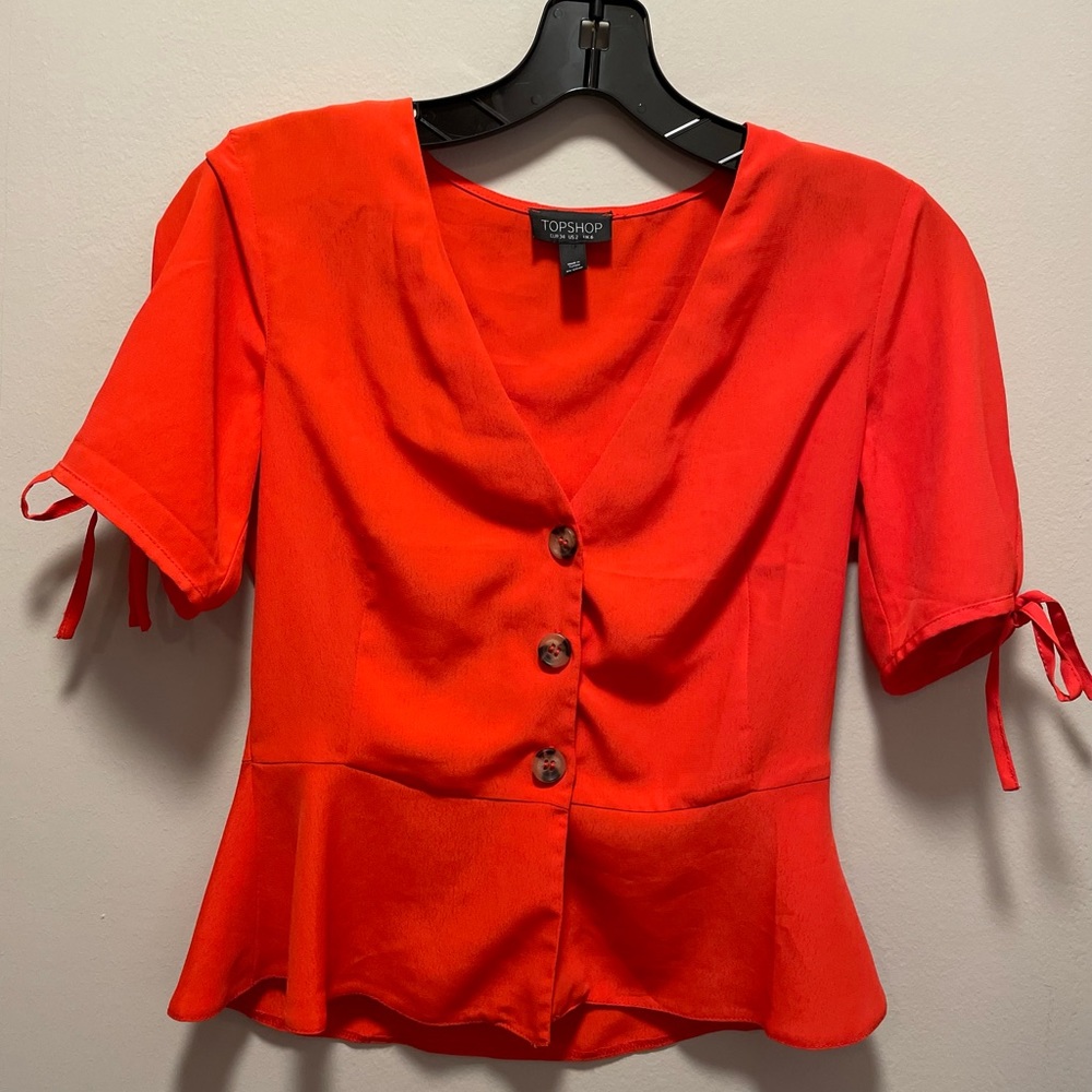 Top shop size 2 poppy red shirt with ties on sleeves. Slight peplum.